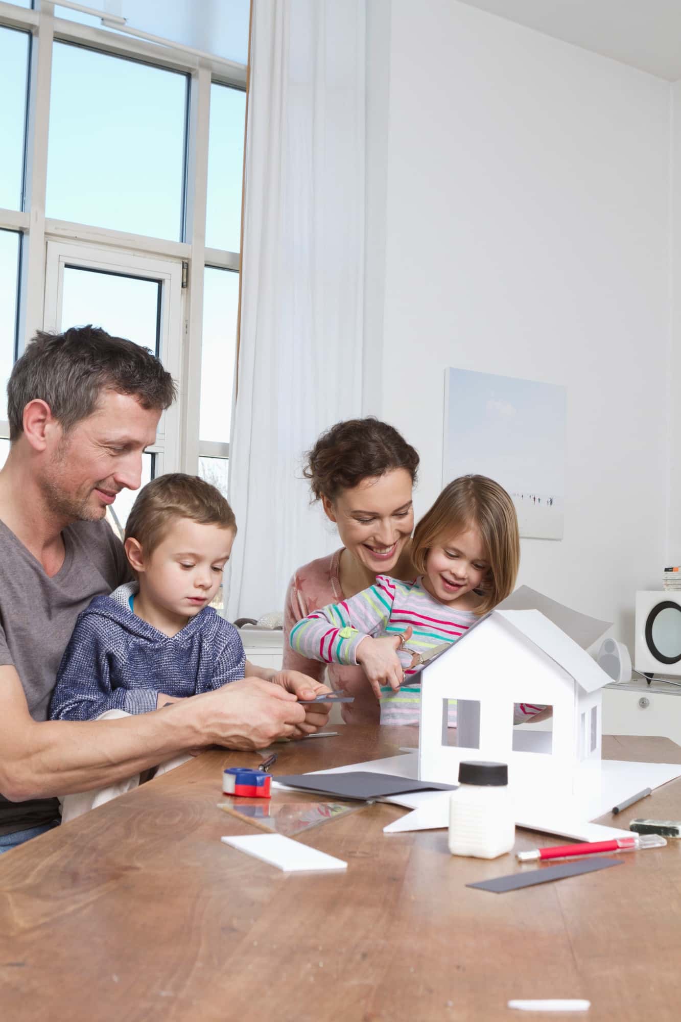 Family of four constructing house model